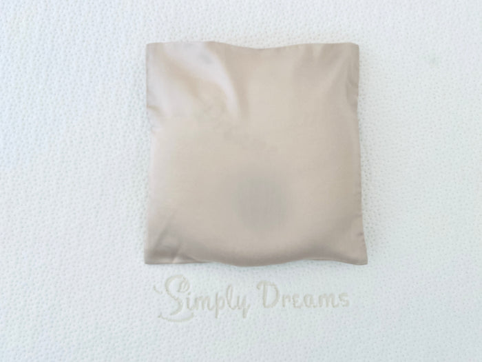White donut-shaped pillow and beige pillowcase