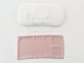 A white head-shaping baby pillow with a pink-colored organic bamboo lyocell pillowcase