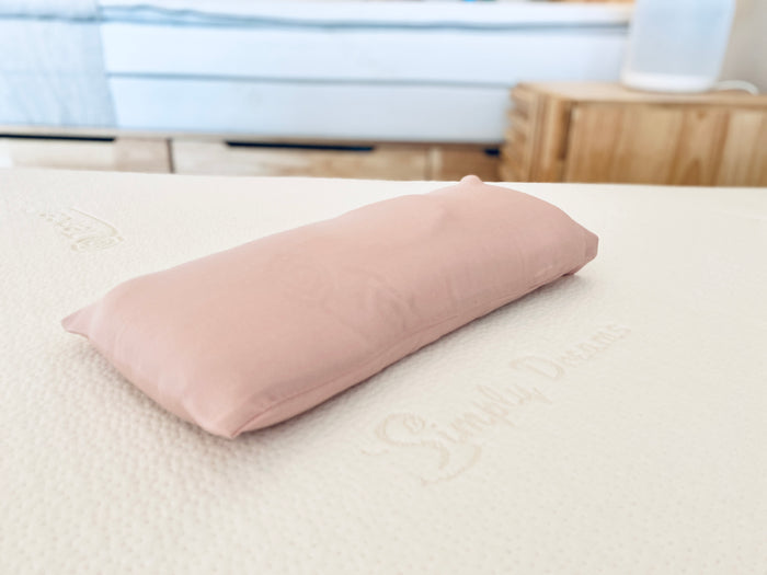 pink organic bamboo lyocell baby pillowcase resting on a mattress