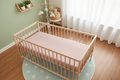 Wooden crib with pink baby mattress in a nursery room